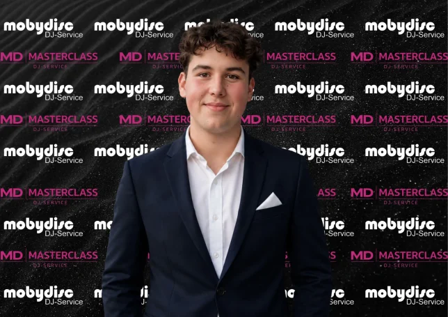 Junger Mobydisc DJ im eleganten Anzug vor professioneller Eventwand