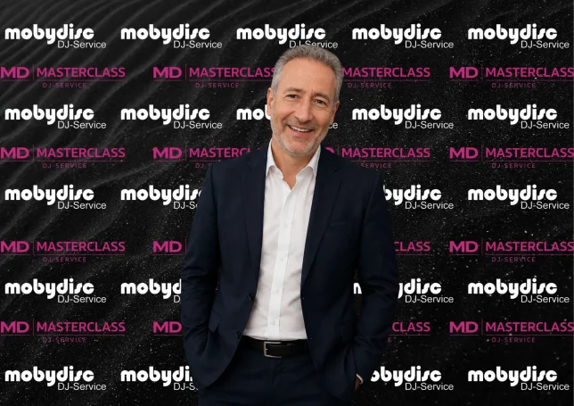 Eleganter Mobydisc Hochzeits-DJ im Business-Look vor Event-Hintergrund